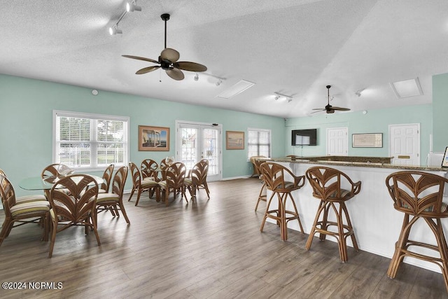 dining space featuring a textured ceiling, french doors, wood finished floors, and rail lighting