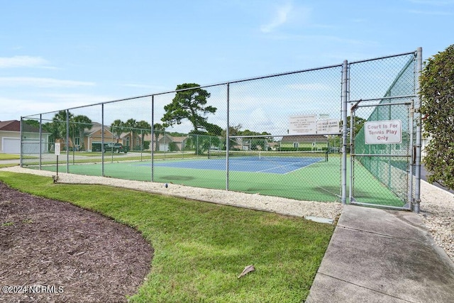 view of sport court with a gate and fence