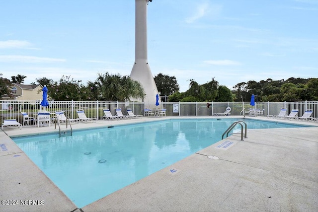 community pool with fence and a patio