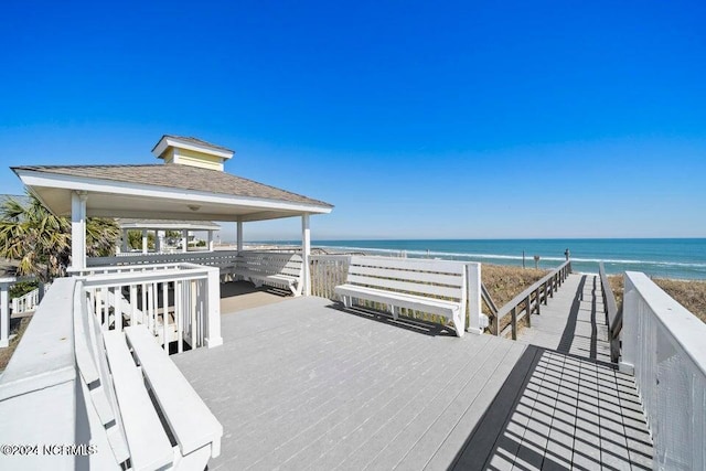 deck with a view of the beach, a water view, and a gazebo