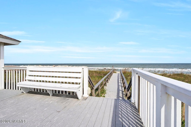 wooden terrace with a view of the beach and a water view