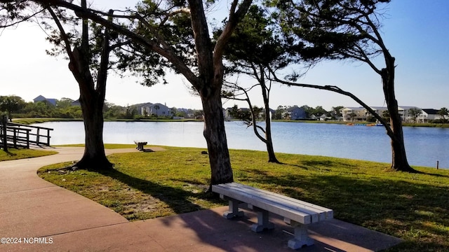 surrounding community featuring a water view and a lawn