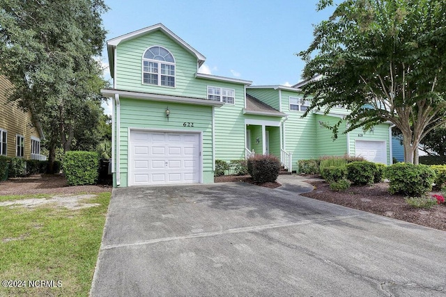 traditional-style house featuring a garage and concrete driveway