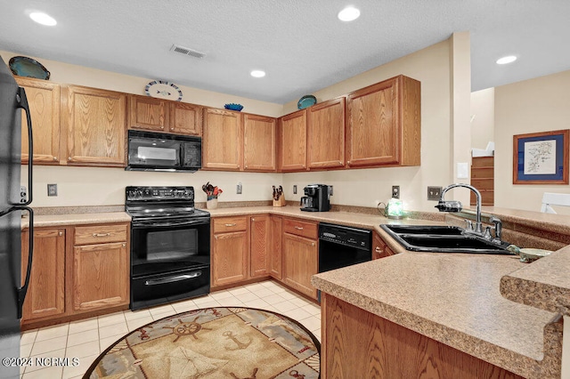 kitchen featuring black appliances, a textured ceiling, light tile patterned flooring, and sink