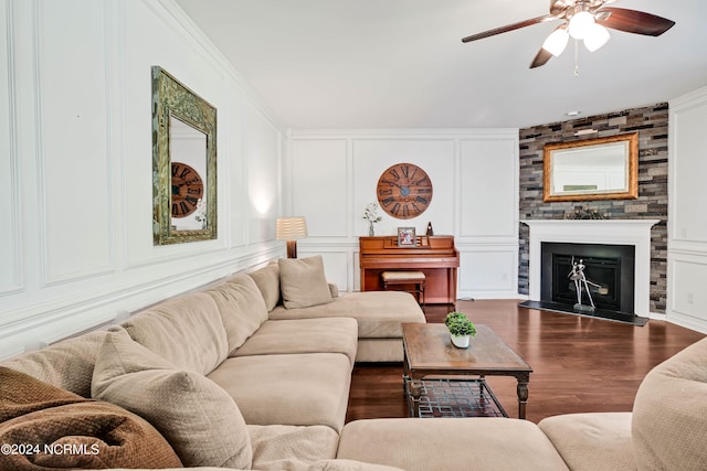 living room with a fireplace, ornamental molding, ceiling fan, and dark hardwood / wood-style floors