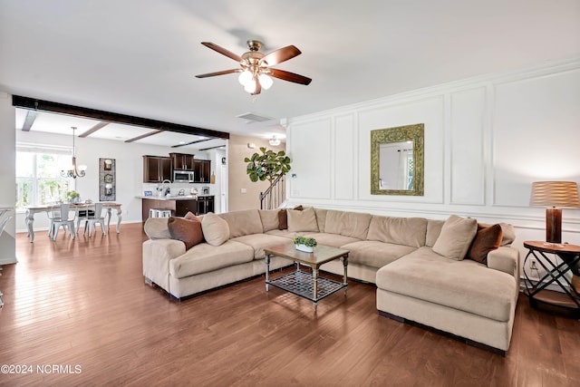 living room featuring ceiling fan, dark hardwood / wood-style floors, and beam ceiling