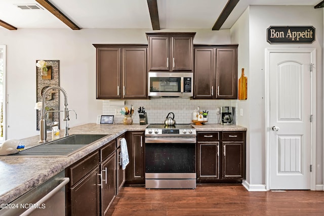 kitchen featuring stainless steel appliances, sink, beam ceiling, and dark hardwood / wood-style flooring