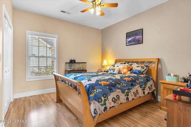 bedroom with ceiling fan, baseboards, visible vents, and light wood-type flooring