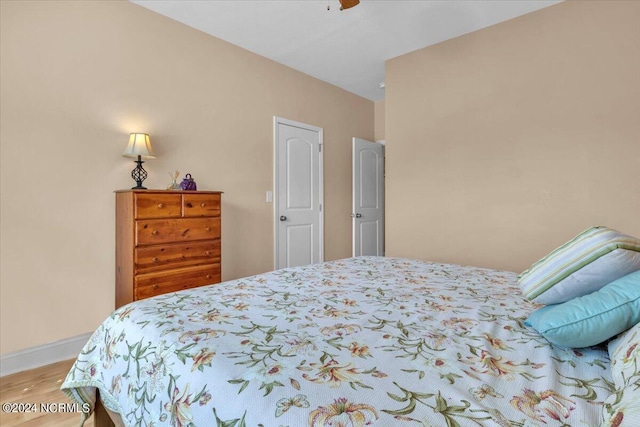 bedroom with ceiling fan, baseboards, and wood finished floors