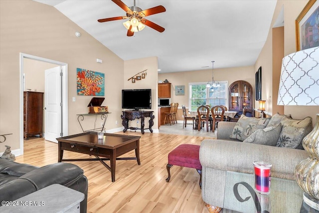 living area featuring light wood-type flooring, baseboards, high vaulted ceiling, and a ceiling fan