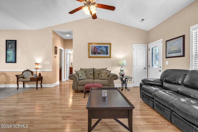 living room featuring light wood-type flooring, visible vents, baseboards, and vaulted ceiling