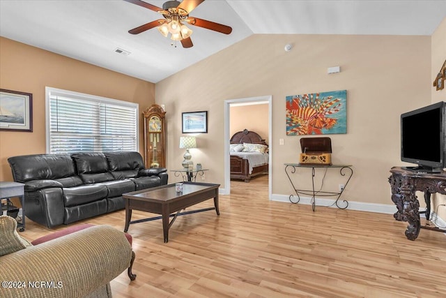 living room featuring visible vents, a ceiling fan, light wood finished floors, baseboards, and vaulted ceiling