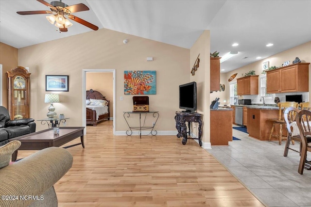 living room featuring light wood-type flooring, a ceiling fan, recessed lighting, baseboards, and vaulted ceiling