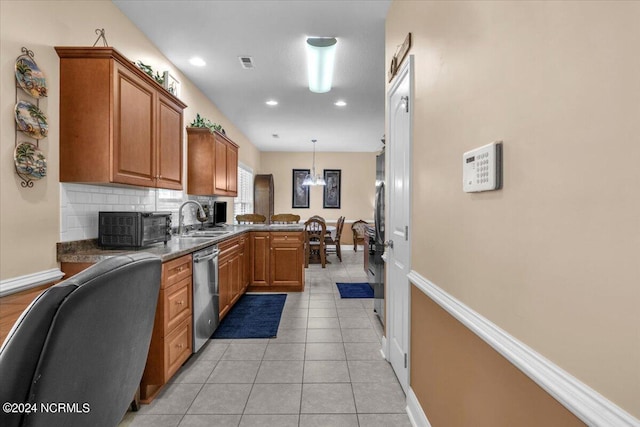 kitchen featuring visible vents, a sink, stainless steel dishwasher, backsplash, and light tile patterned floors