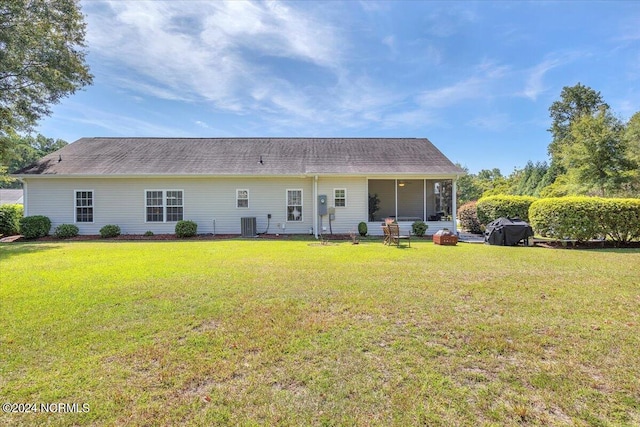 rear view of property featuring a yard and a sunroom