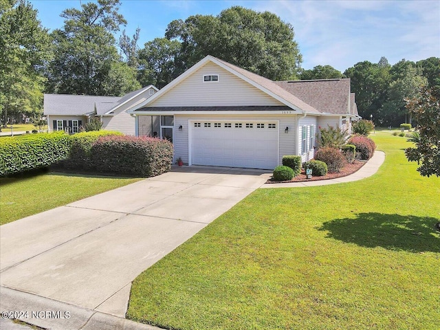 view of front of home with an attached garage, concrete driveway, and a front lawn