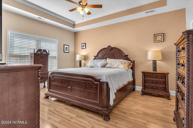 bedroom with visible vents, light wood-style floors, and ornamental molding