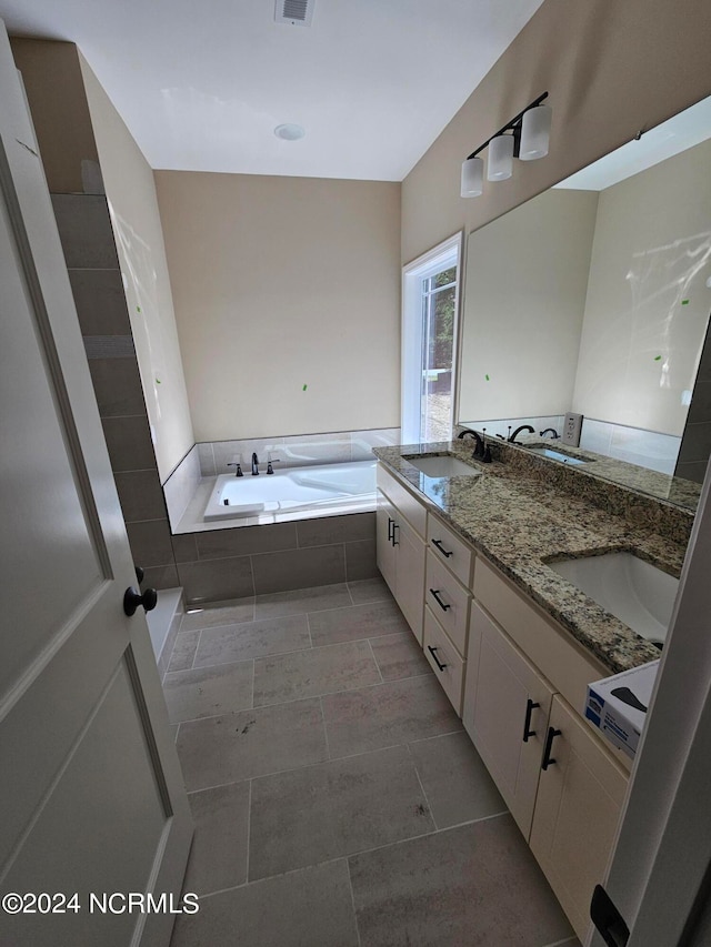 bathroom with vanity and a relaxing tiled tub