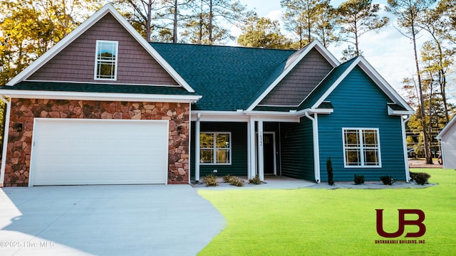 craftsman house with a garage and a front lawn