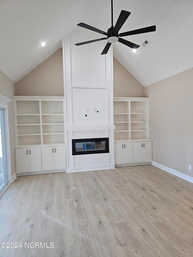 unfurnished living room with ceiling fan, light wood-type flooring, and vaulted ceiling