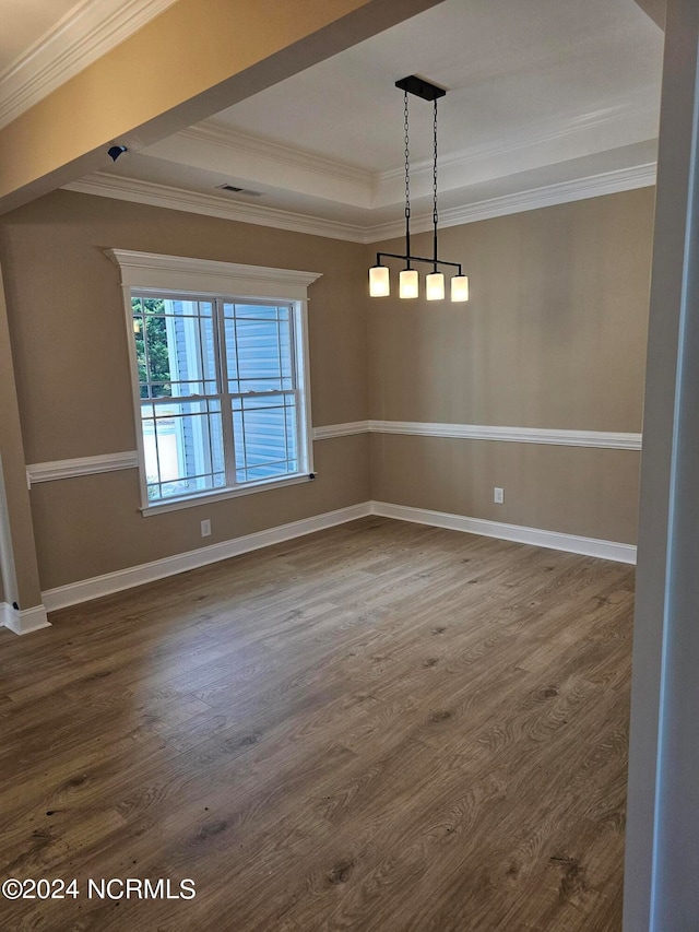 unfurnished dining area featuring a raised ceiling, crown molding, and hardwood / wood-style floors