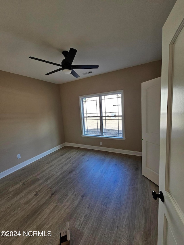 spare room featuring ceiling fan and dark hardwood / wood-style flooring