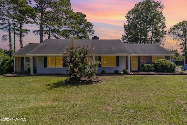 single story home featuring a lawn and a porch