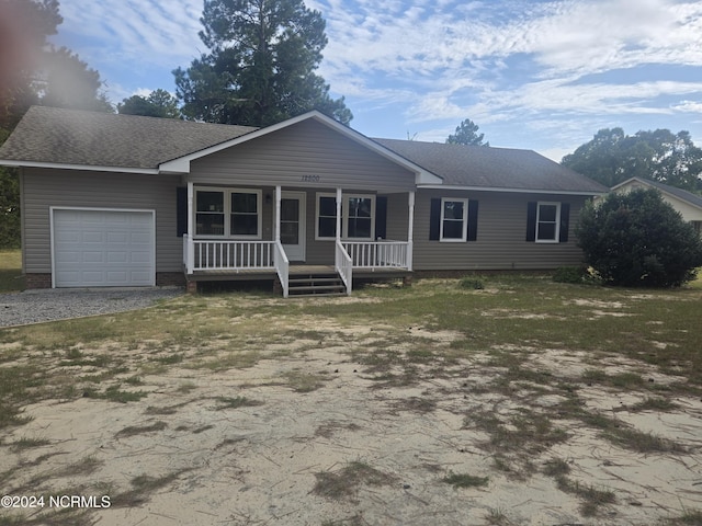 ranch-style home featuring a garage, covered porch, and a shingled roof