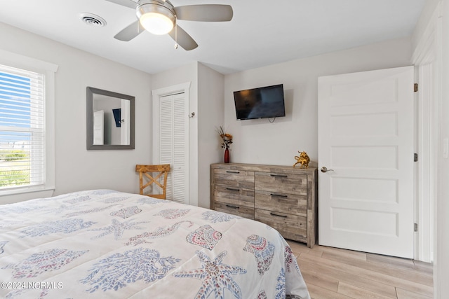 bedroom with a closet, ceiling fan, and light wood-type flooring