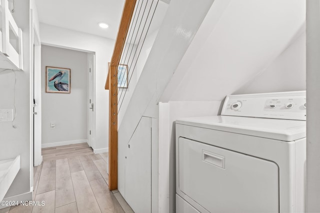 clothes washing area featuring washer / dryer and light hardwood / wood-style flooring