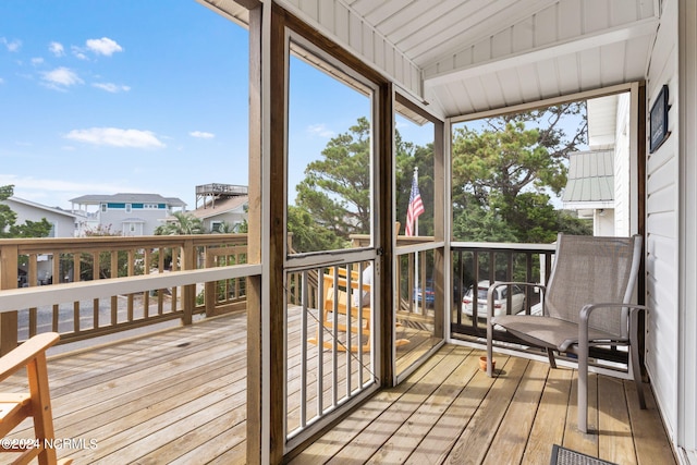 sunroom with vaulted ceiling and a healthy amount of sunlight