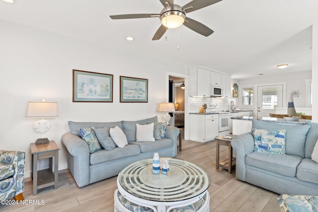 living room featuring ceiling fan and light hardwood / wood-style flooring