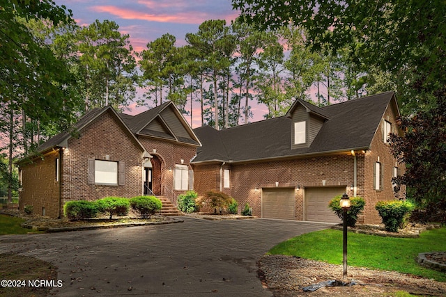 view of front of property with a garage and a yard