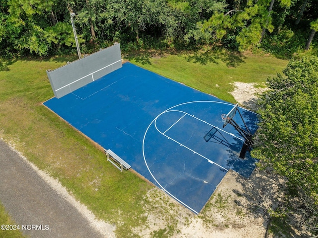 view of basketball court with a yard