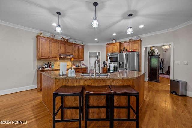 kitchen featuring a center island with sink, light hardwood / wood-style flooring, stainless steel appliances, and sink