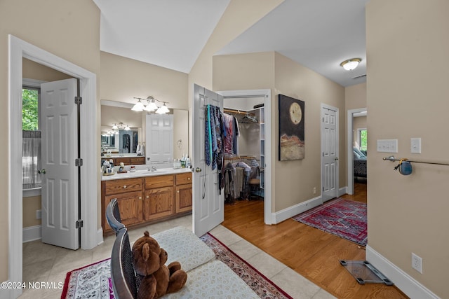 bathroom featuring vanity, lofted ceiling, and hardwood / wood-style flooring