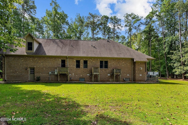 rear view of house featuring a yard