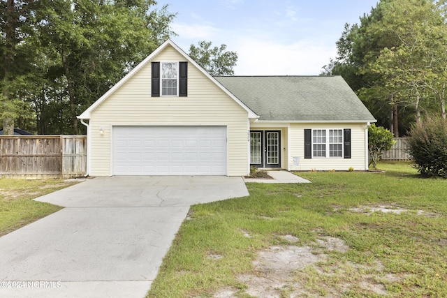 traditional-style home featuring a garage, a shingled roof, fence, concrete driveway, and a front lawn