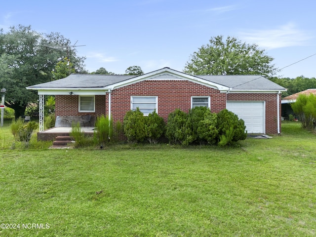 view of property exterior featuring a garage, brick siding, a lawn, and covered porch