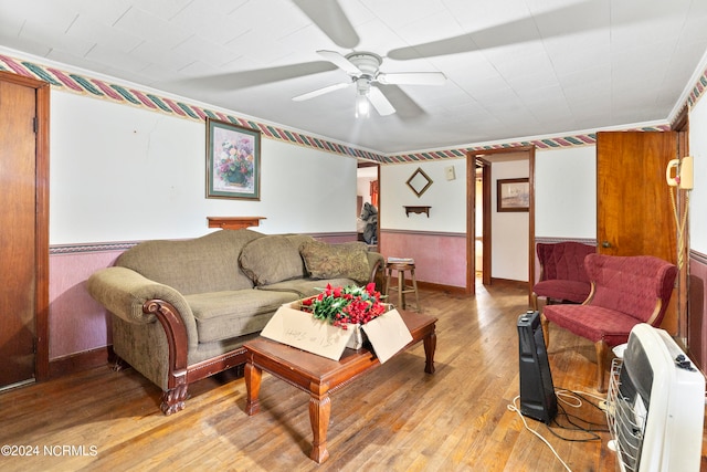 living room featuring heating unit, light hardwood / wood-style floors, and ceiling fan