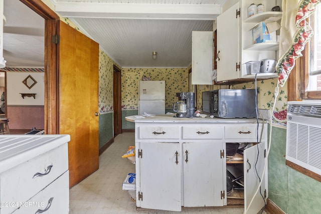 kitchen featuring wallpapered walls, white cabinetry, light countertops, freestanding refrigerator, and open shelves