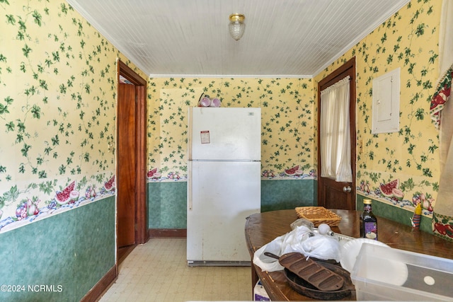 kitchen with crown molding, electric panel, and white refrigerator