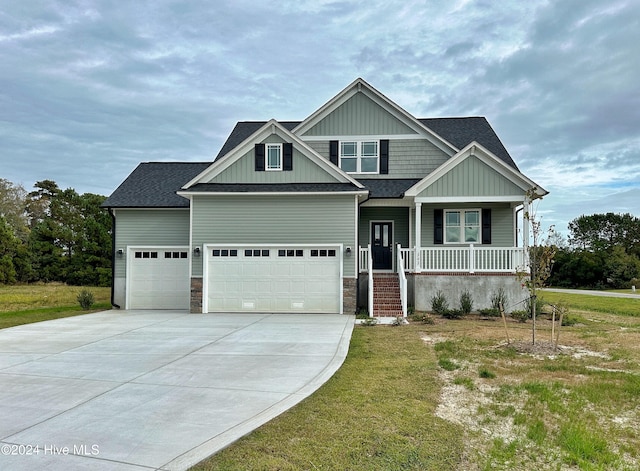 craftsman-style house with a front yard, a porch, and a garage