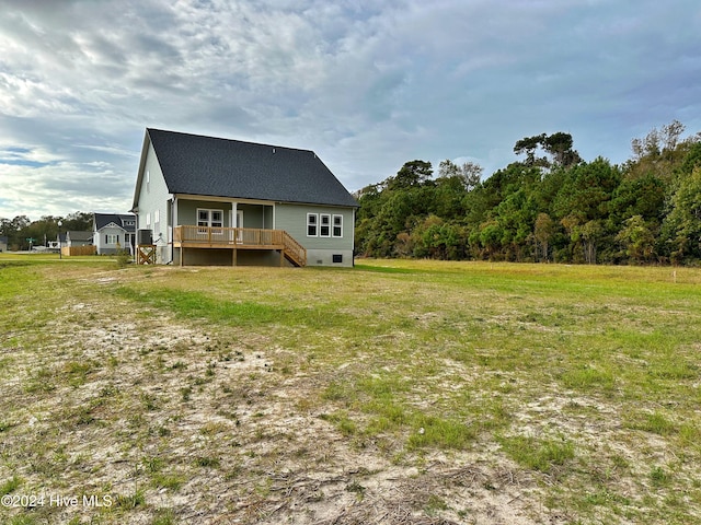 rear view of house with a yard and a wooden deck