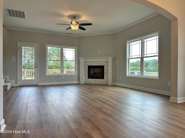 unfurnished living room featuring ceiling fan, crown molding, a healthy amount of sunlight, and dark hardwood / wood-style floors