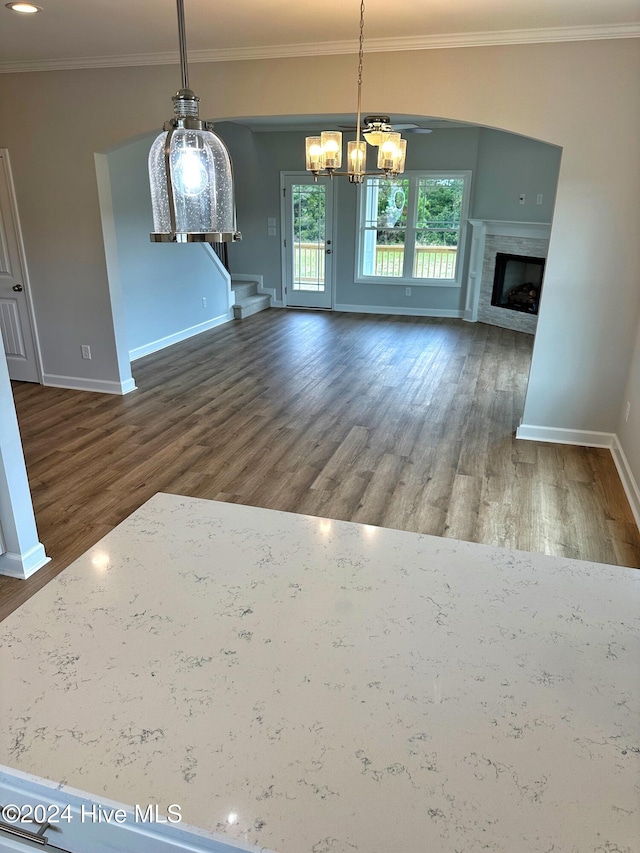 unfurnished dining area featuring a chandelier, wood-type flooring, and crown molding