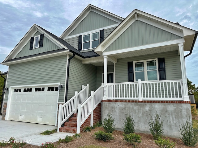 view of front facade featuring covered porch, a garage, and cooling unit