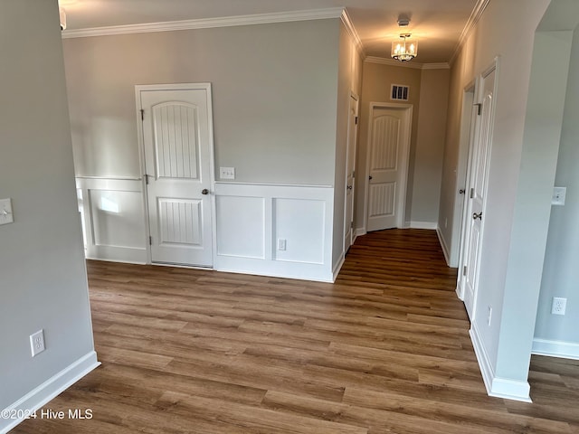 hall featuring hardwood / wood-style flooring, a notable chandelier, and crown molding