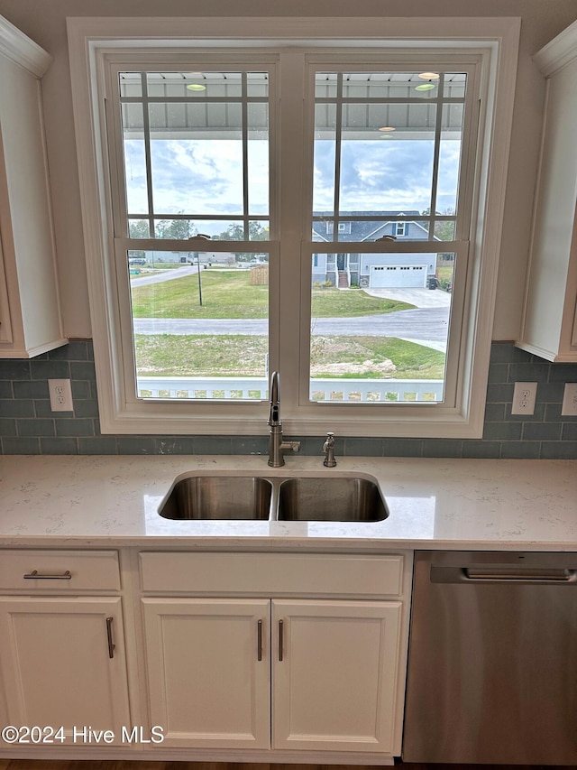 kitchen featuring dishwasher, decorative backsplash, white cabinetry, and sink