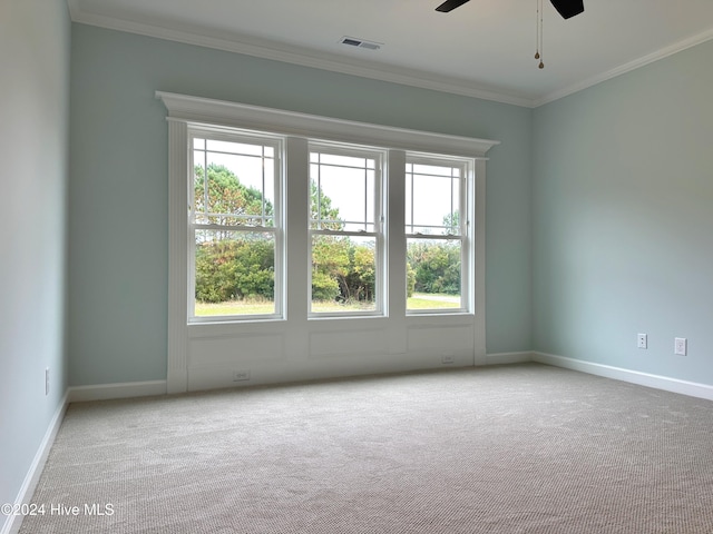 carpeted empty room with plenty of natural light, crown molding, and ceiling fan